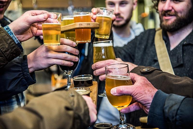 A group toasting craft beers on the Bermondsey Beer Mile, including an Anspach & Hobday tasting flight